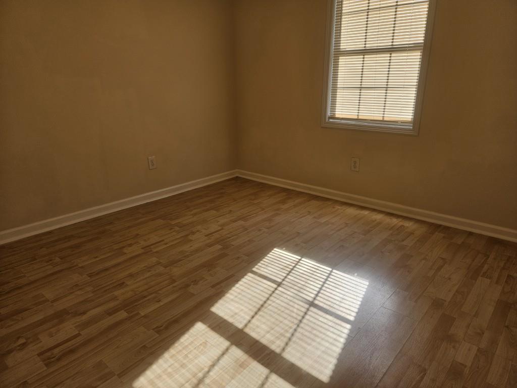 4121 Burgundy Way Flowery Branch, GA 30542 - Photo 8 of 15 an empty room with wooden floor and windows
