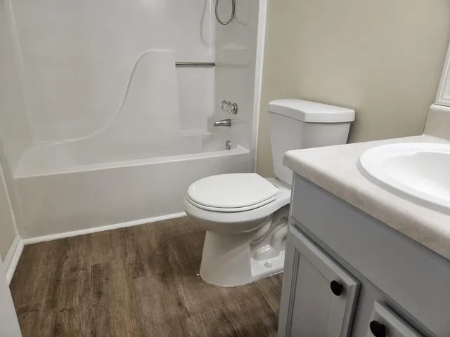 a white toilet sitting next to a bath tub