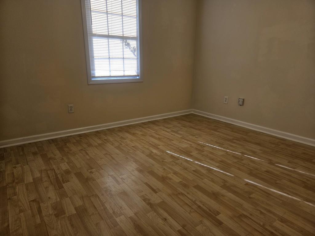 4121 Burgundy Way Flowery Branch, GA 30542 - Photo 10 of 15 a view of an empty room with wooden floor and a window
