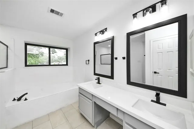 a bathroom with a double vanity sink and a mirror