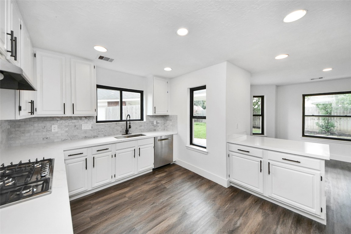 8510 Canyon Pine Drive Spring, TX 77379 - Photo 7 of 42 a large white kitchen with granite countertop a stove a sink a refrigerator and white cabinets with wooden floor