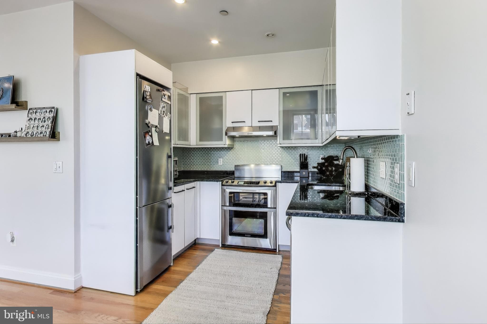 1406 T Street Northwest, Unit 6 Washington, DC 20009 - Photo 13 of 31 a kitchen with stainless steel appliances granite countertop a stove a refrigerator and a sink