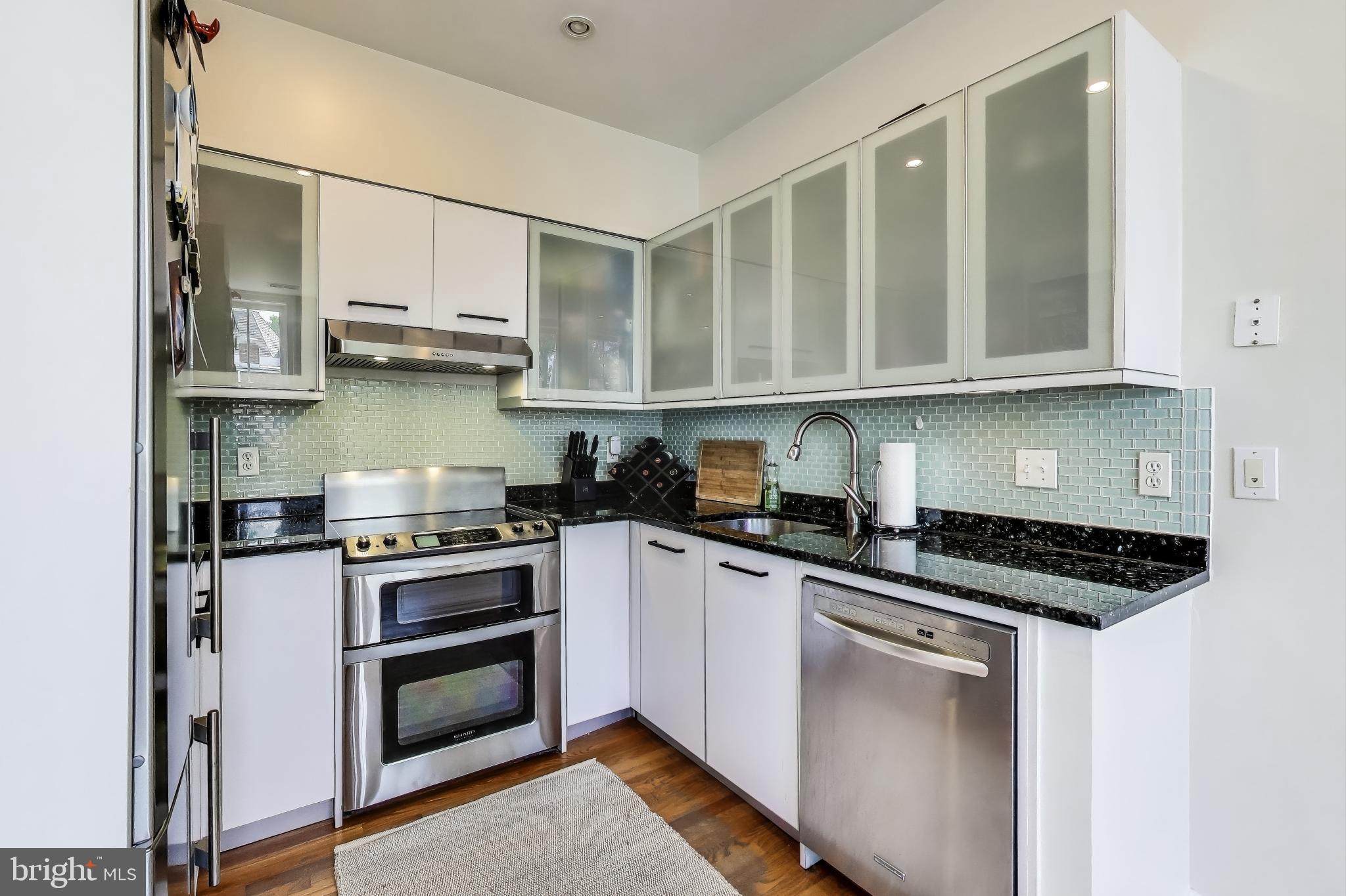 1406 T Street Northwest, Unit 6 Washington, DC 20009 - Photo 14 of 31 a kitchen with stainless steel appliances a stove a sink and cabinets