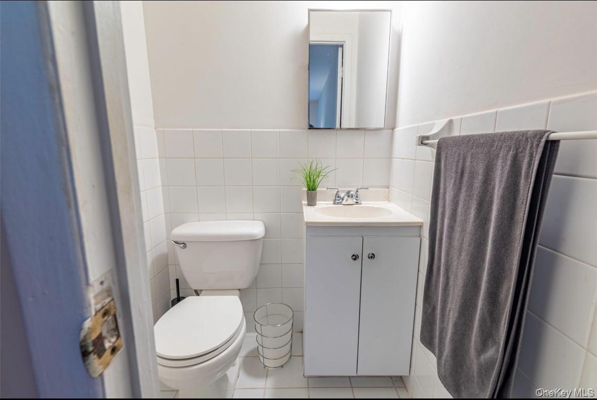 18-16 Bell Boulevard, Unit 3 Queens, NY 11360 - Photo 12 of 12 a white toilet sitting next to a bathroom sink