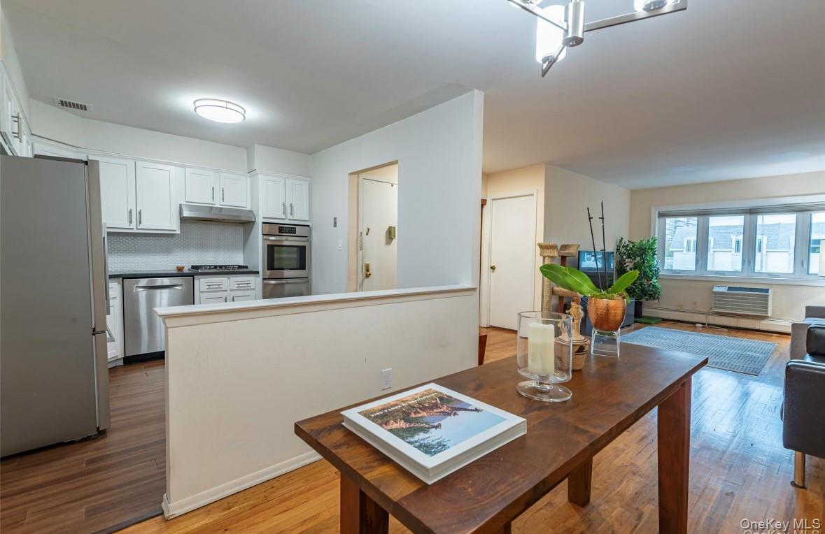 18-16 Bell Boulevard, Unit 3 Queens, NY 11360 - Photo 3 of 12 a living room with stainless steel appliances kitchen island a table and chairs