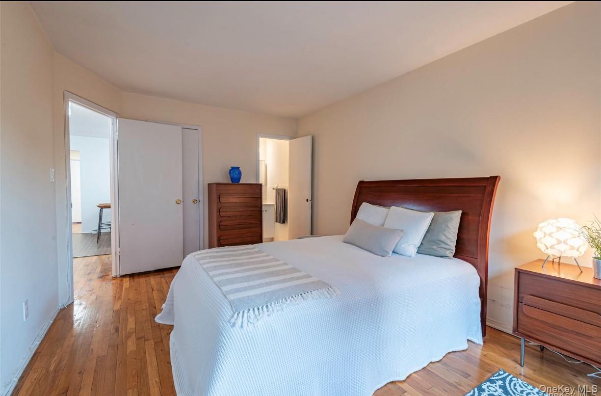 18-16 Bell Boulevard, Unit 3 Queens, NY 11360 - Photo 7 of 12 a bedroom with a bed and wooden floor