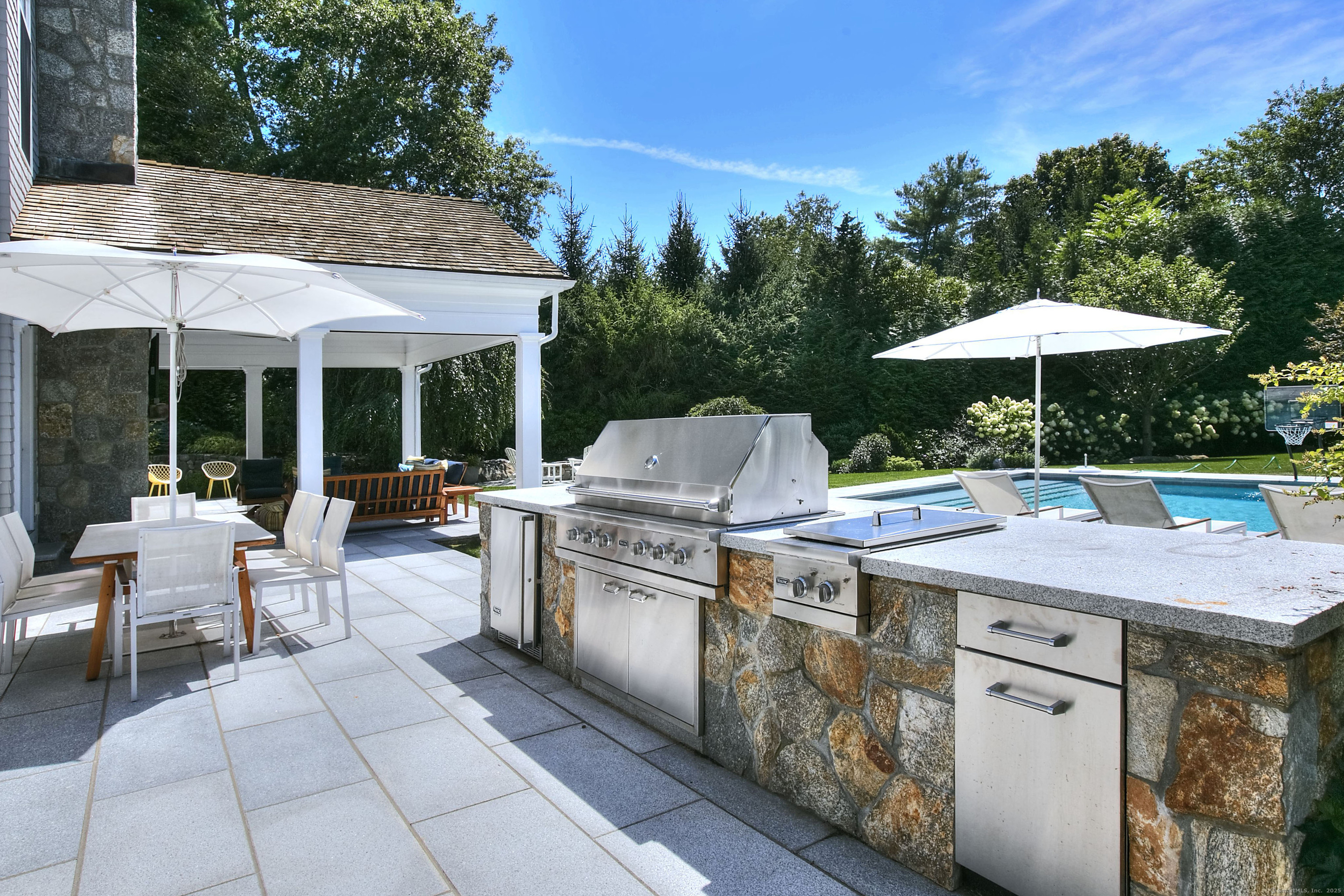10 Debra Lane Westport, CT 06880 - Photo 7 of 40 a view of a patio with table and chairs under an umbrella