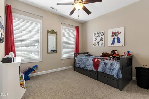 a living room with furniture a clock and a ceiling fan