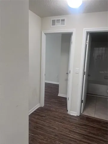 an empty room with wooden floor and closet