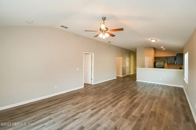 a view of a kitchen with wooden floor and a ceiling fan
