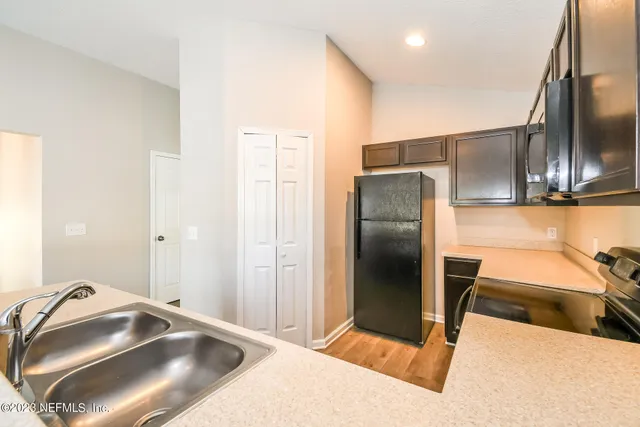 a kitchen with stainless steel appliances granite countertop a sink and a refrigerator