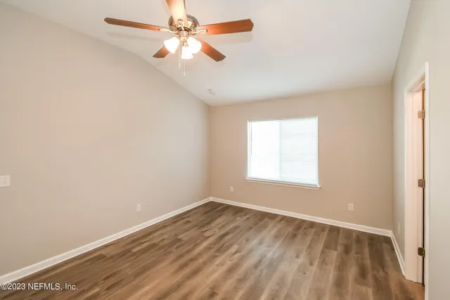 an empty room with a window and a fan
