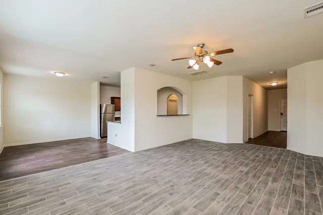 a view of a big room with wooden floor and a ceiling fan