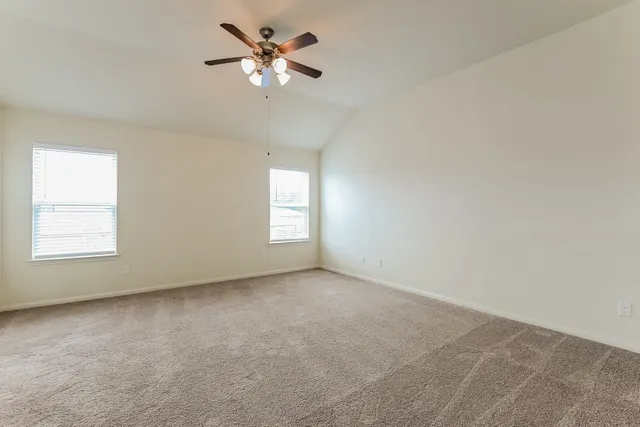 an empty room with a window and a ceiling fan