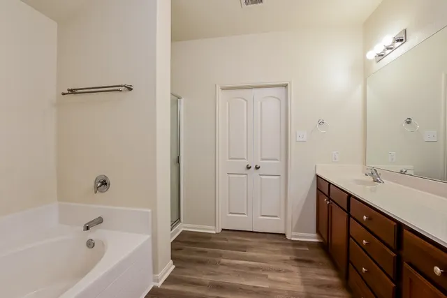 a bathroom with a tub sink and mirror
