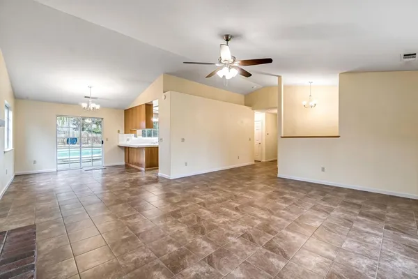 a view of empty room with wooden floor and ceiling fan