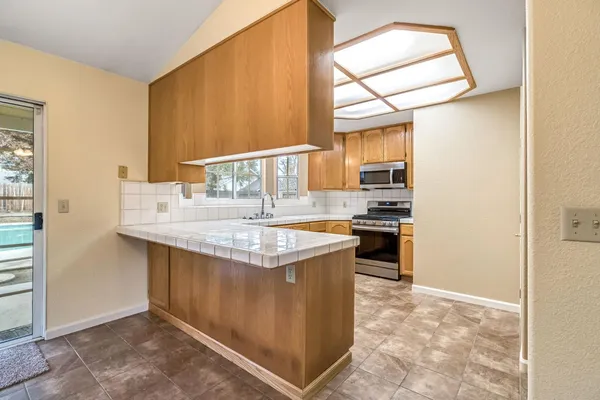 a kitchen with stainless steel appliances granite countertop a stove a sink and a refrigerator