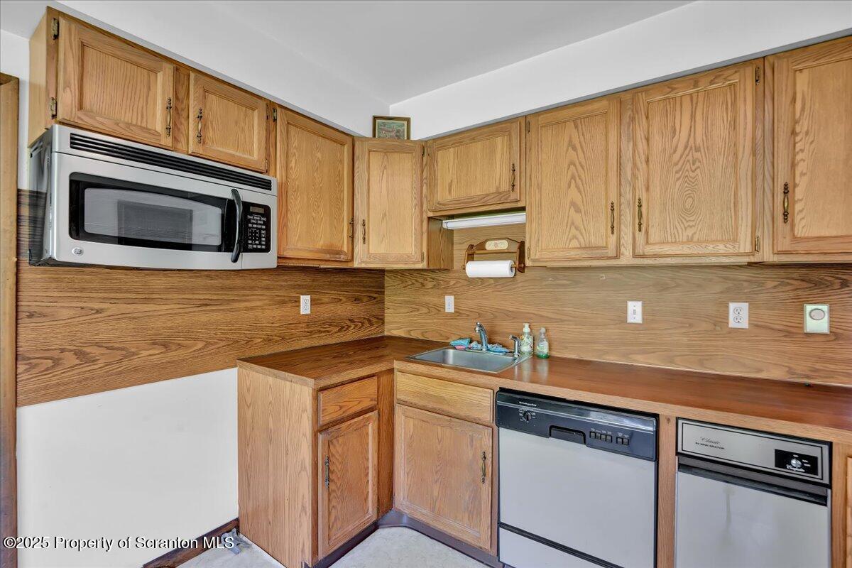 906 Violet Terrace Clarks Summit, PA 18411 - Photo 17 of 38 a kitchen with stainless steel appliances granite countertop a sink stove and microwave