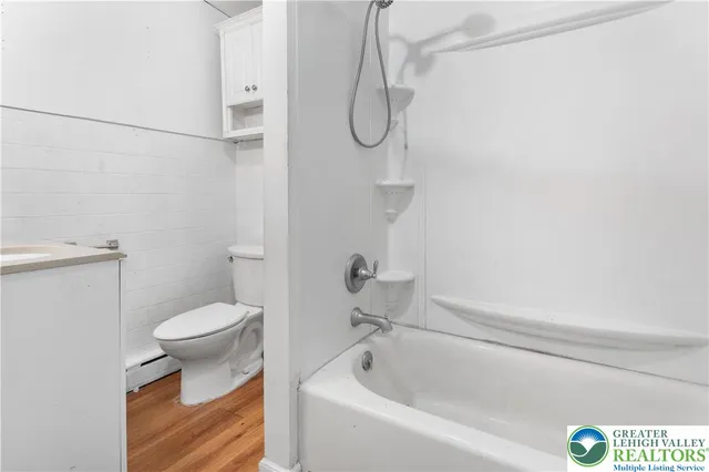 a view of an empty room with wooden floor