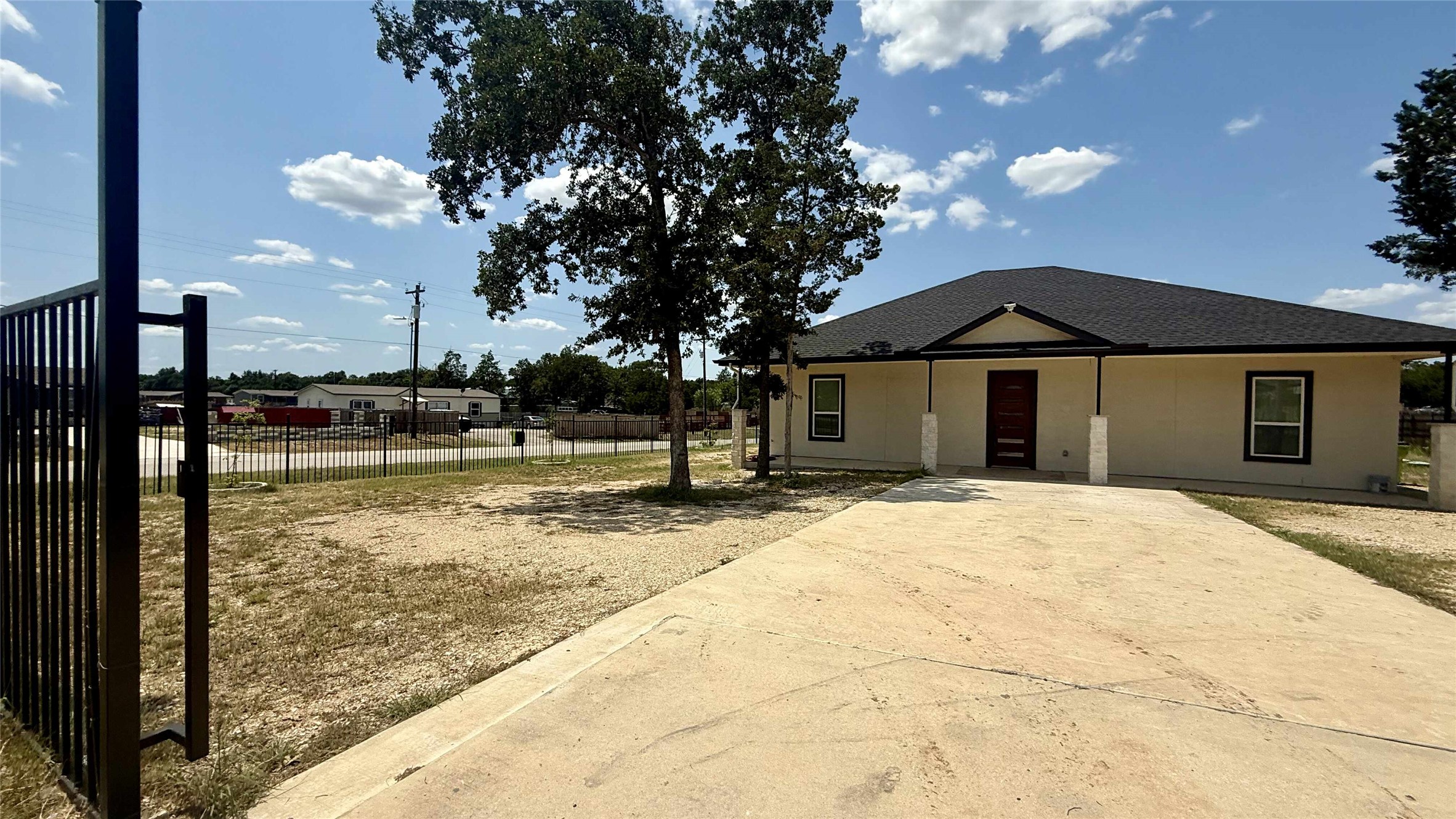 View of front facade featuring roof with shingles and stucco siding
