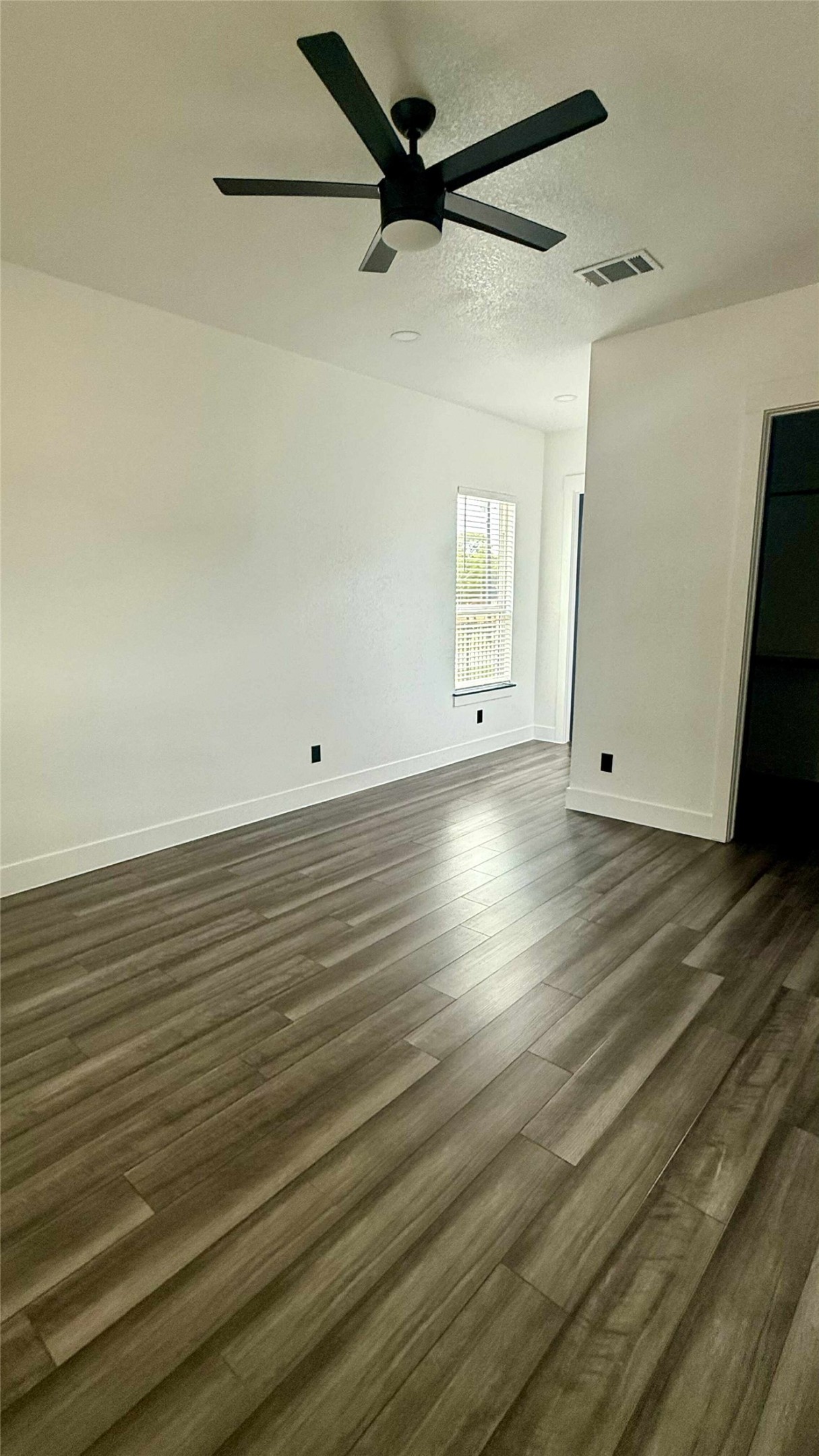 146 Buena Fortuna Road Elgin, TX 78621 - Photo 3 of 15 a view of a room with wooden floor and a ceiling fan