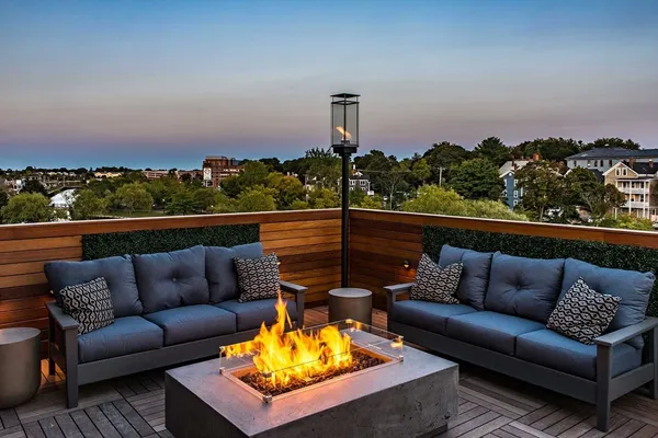 a view of a roof deck with couches and sky view
