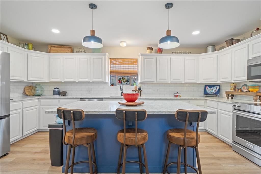 311 Blue Water Drive Portland, TX 78374 - Photo 10 of 25 a kitchen with stainless steel appliances granite countertop a dining table chairs stove and white cabinets