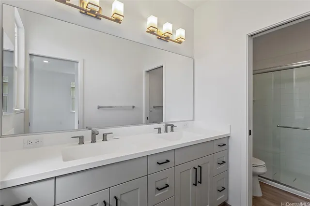 a bathroom with a double vanity sink mirror and toilet