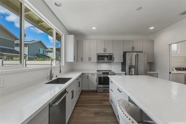 a kitchen with stainless steel appliances granite countertop a sink a stove and a refrigerator