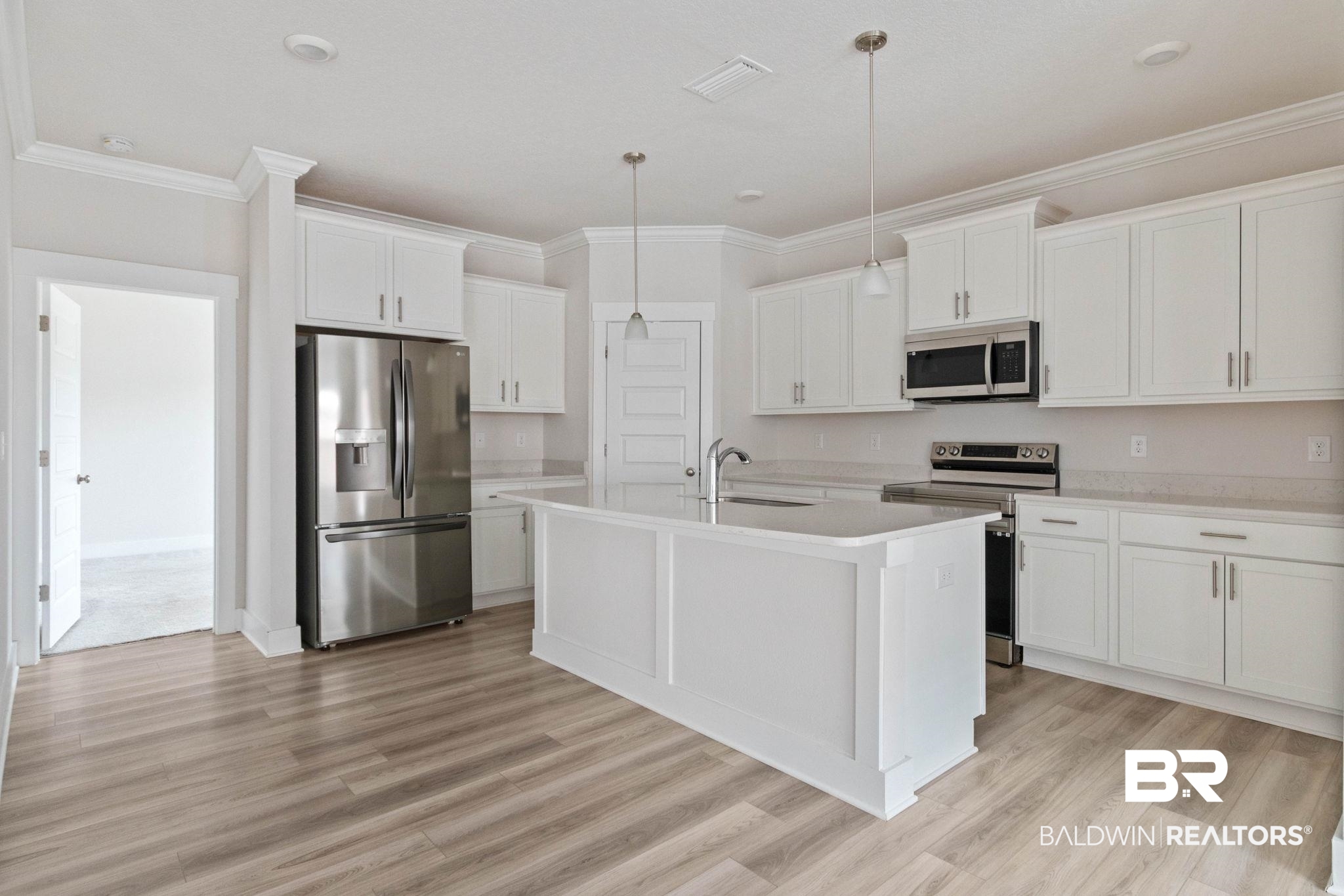 1710 Grouse Street Foley, AL 36535 - Photo 23 of 76 Kitchen featuring a central island, white shaker cabinetry, stainless steel appliances, and wood-finish flooring