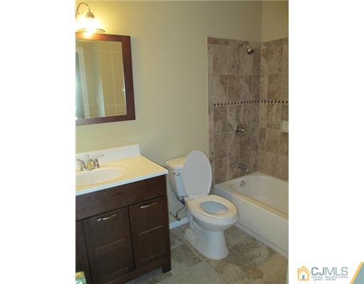 12 Indiana Road Somerset, NJ 08873 - Photo 7 of 12 a bathroom with a sink toilet a mirror and shower
