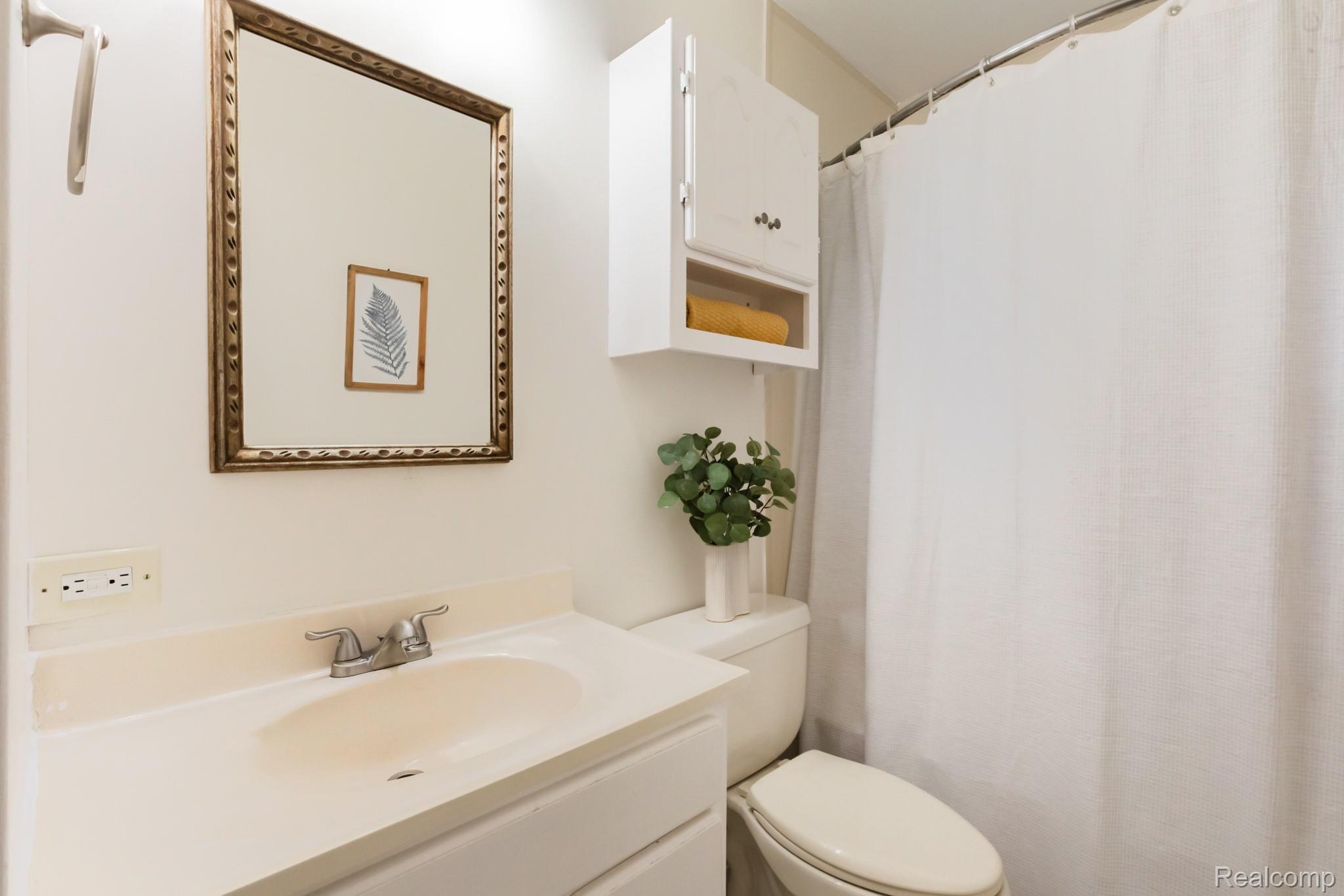 3882 Okemos Road Okemos, MI 48864 - Photo 22 of 50 Vanity with an integrated sink, polished chrome faucet, and framed mirror