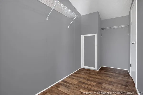 a kitchen with stainless steel appliances granite countertop a refrigerator a sink dishwasher a stove and white countertops with wooden floor