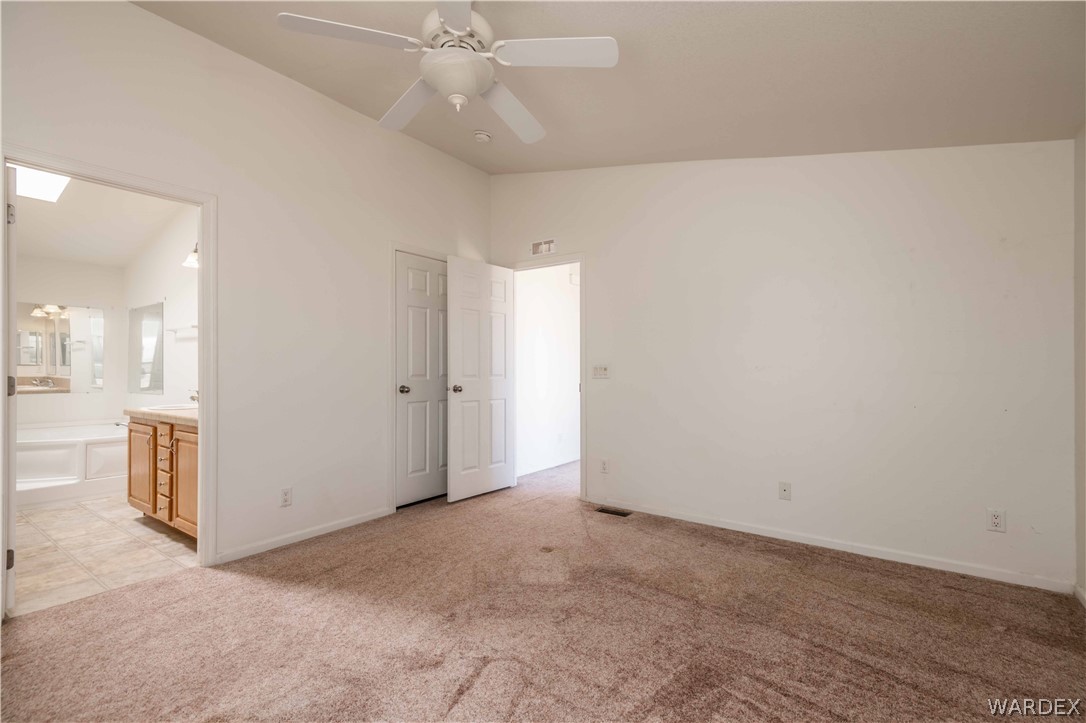 4229 Cove Road Golden Valley, AZ 86413 - Photo 14 of 36 an empty room with a kitchen and a chandelier fan