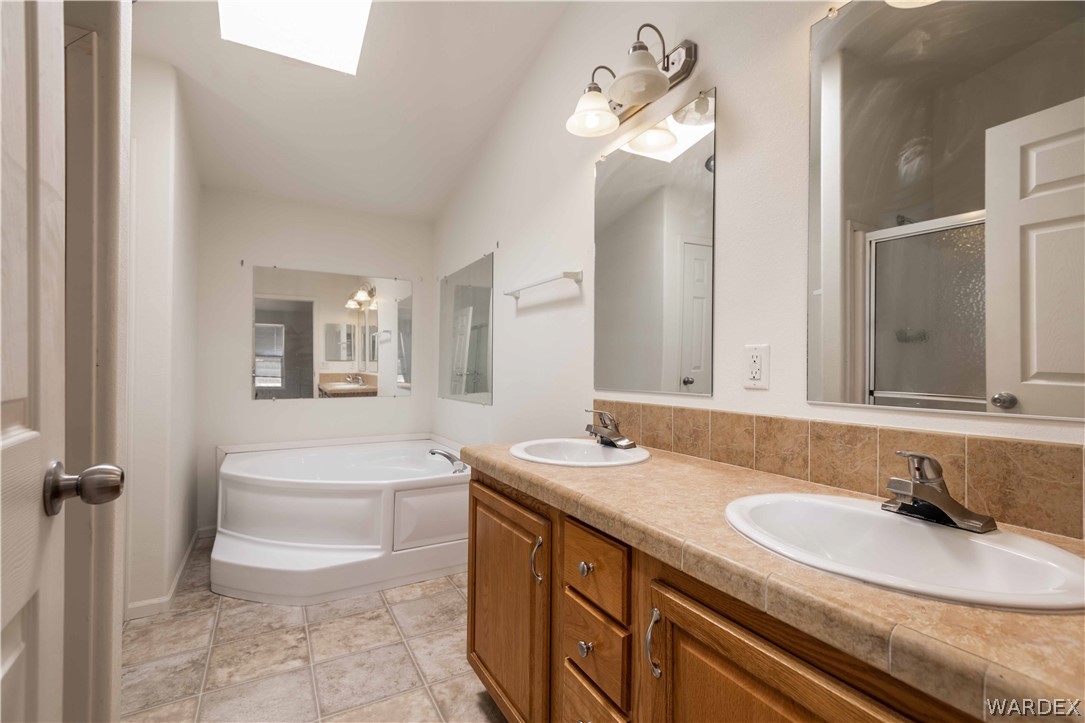 4229 Cove Road Golden Valley, AZ 86413 - Photo 16 of 36 a bathroom with a double vanity sink a toilet and a mirror