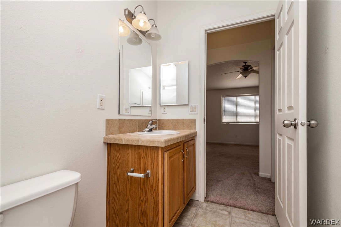 4229 Cove Road Golden Valley, AZ 86413 - Photo 23 of 36 a bathroom with a sink a toilet and mirror