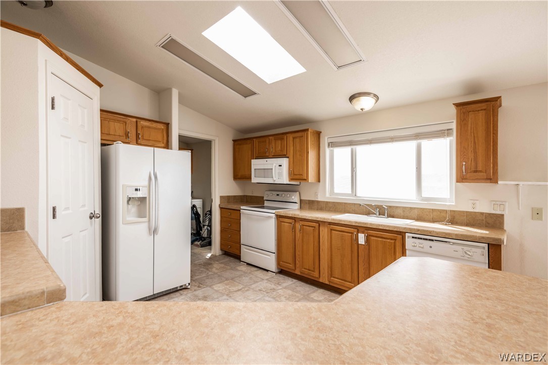 4229 Cove Road Golden Valley, AZ 86413 - Photo 6 of 36 a large white kitchen with stainless steel appliances granite countertop a refrigerator and a stove top oven