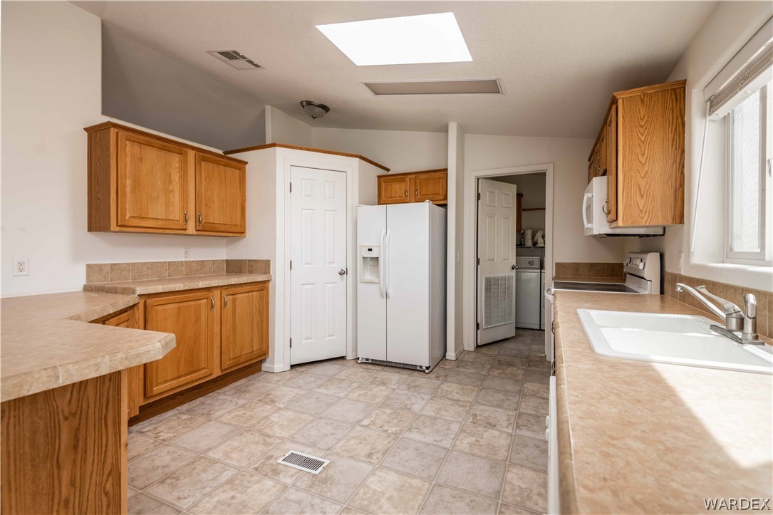 4229 Cove Road Golden Valley, AZ 86413 - Photo 7 of 36 a view of a kitchen with a sink dishwasher stove and a refrigerator