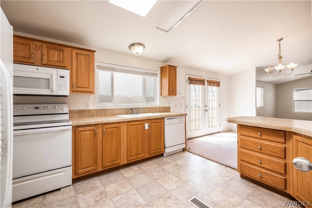 4229 Cove Road Golden Valley, AZ 86413 - Photo 8 of 36 a kitchen with granite countertop white cabinets and white appliances