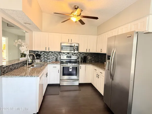 a kitchen with stainless steel appliances a stove a sink and a refrigerator