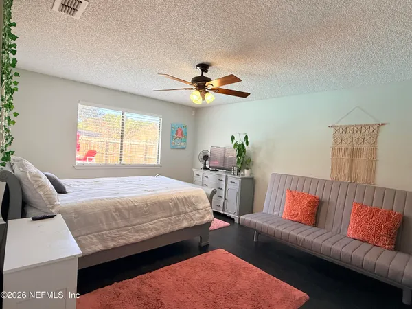 a bedroom with a bed couch and window