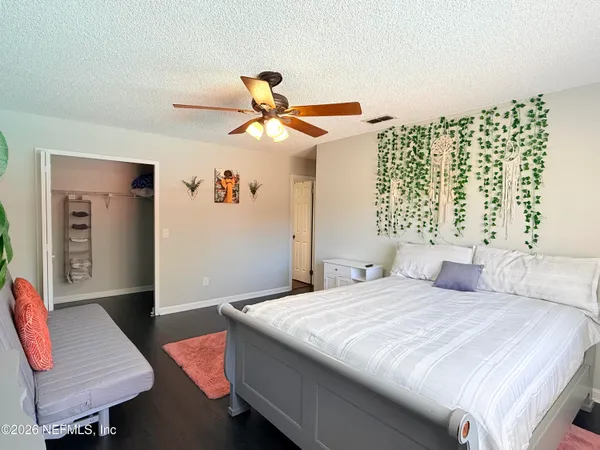 a bedroom with a bed a dresser and a window