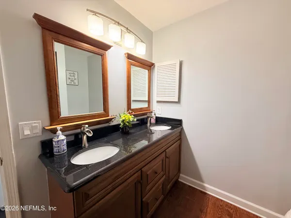 a bathroom with a granite countertop sink and a mirror