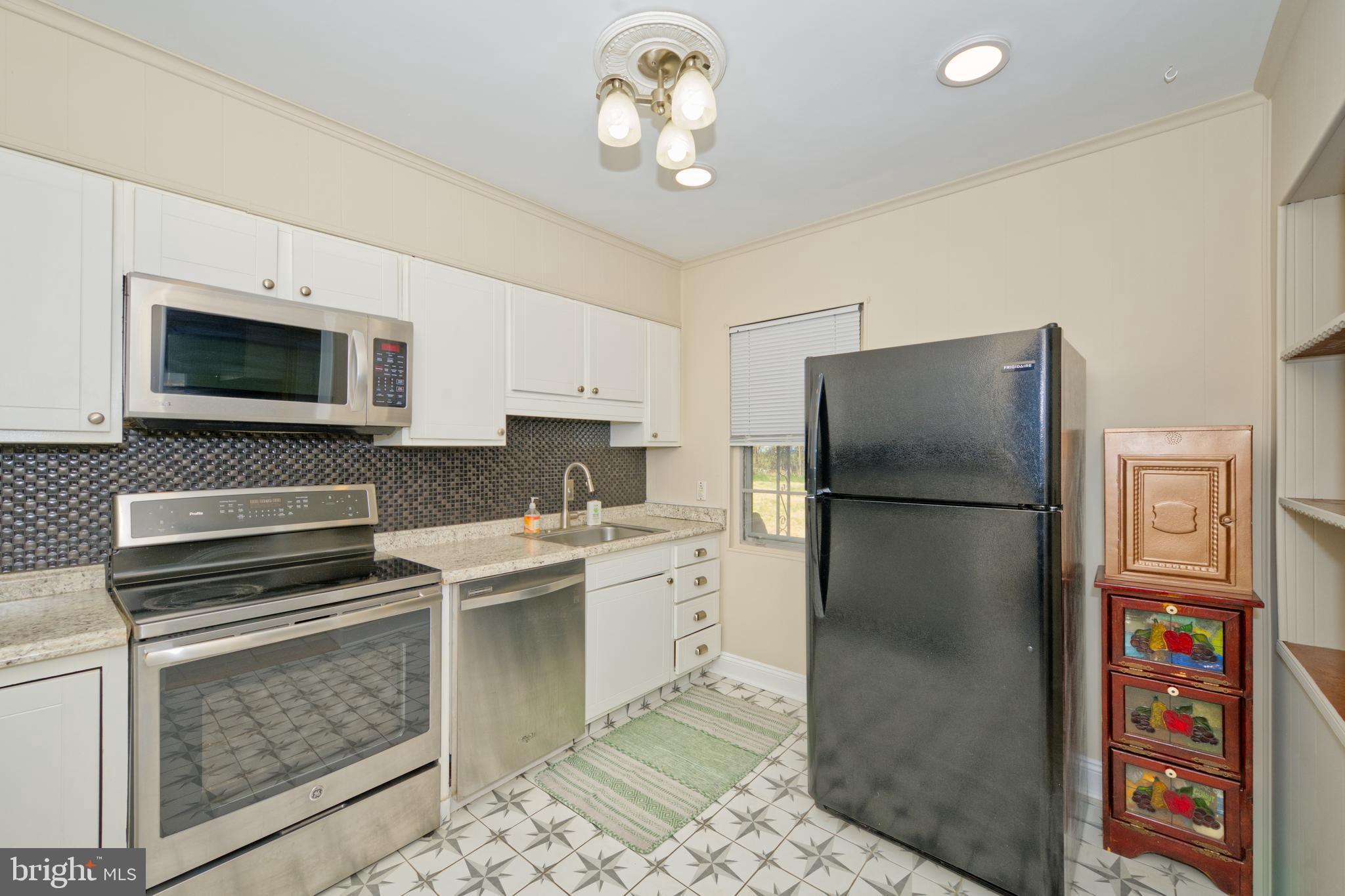 89 Cooper Road Dover, DE 19901 - Photo 18 of 32 a kitchen with a refrigerator a stove a microwave and cabinets