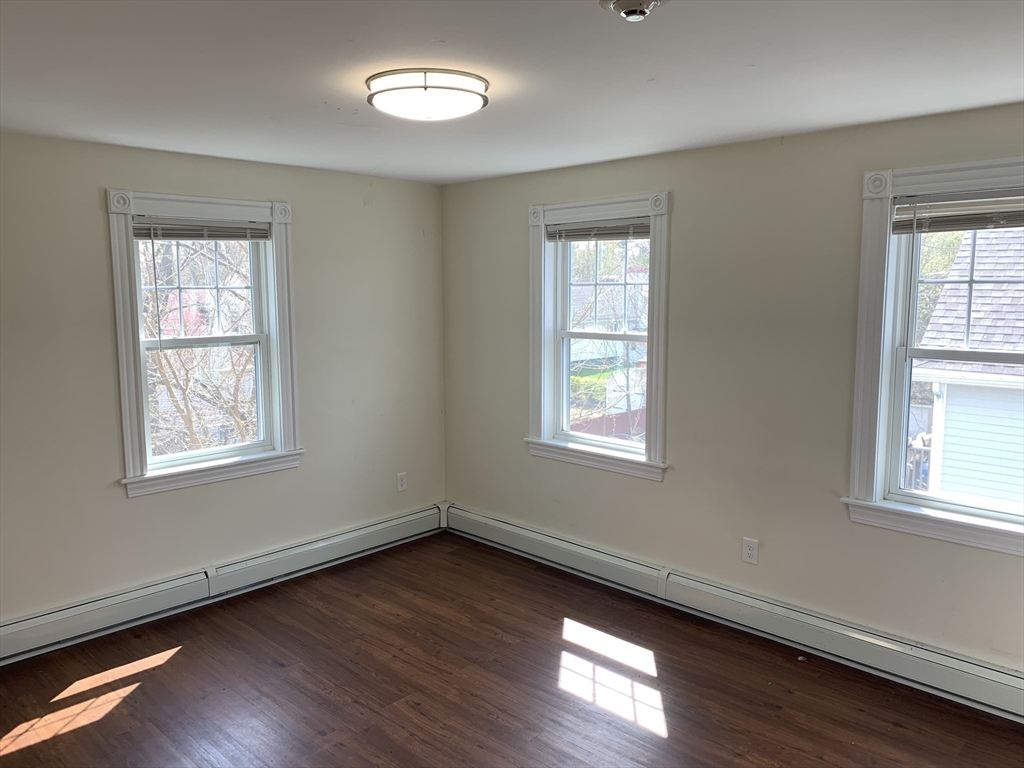 2 Coburn Street, Unit 6 Framingham, MA 01702 - Photo 4 of 7 a view of an empty room with wooden floor and a window