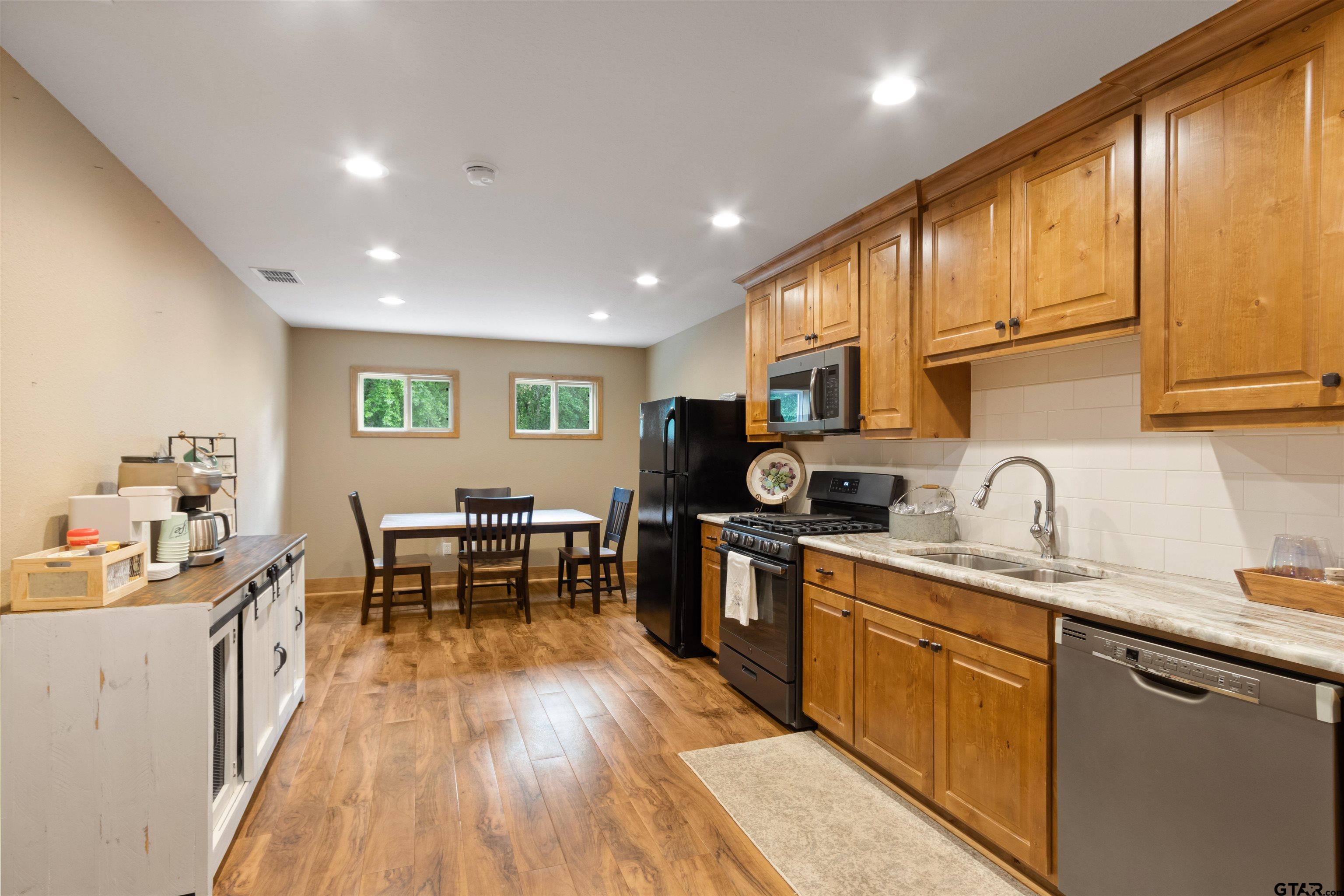 1506 Hamby Road Longview, TX 75605 - Photo 38 of 48 a kitchen with stainless steel appliances granite countertop sink stove top oven and cabinets