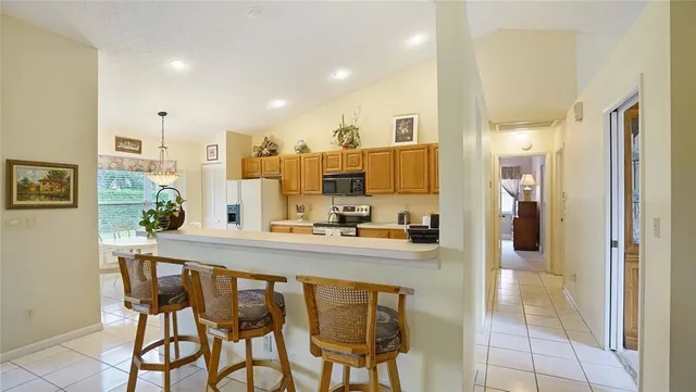 a kitchen with stainless steel appliances kitchen island granite countertop a refrigerator and cabinets