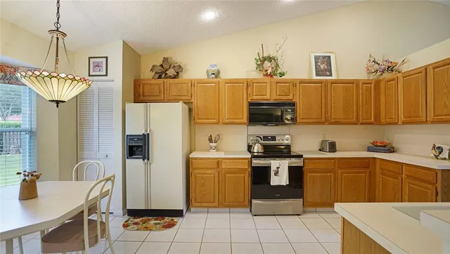 a kitchen with stainless steel appliances granite countertop a sink a stove and refrigerator