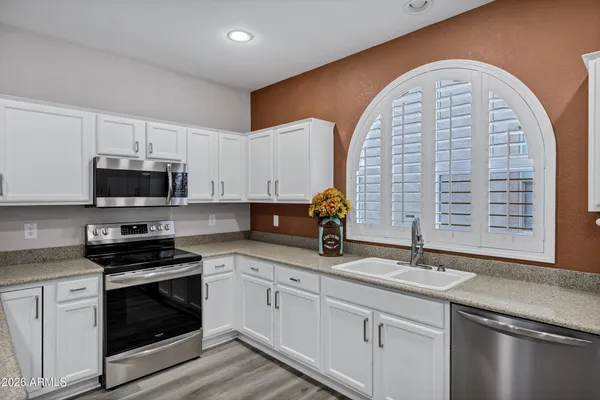 a kitchen with stainless steel appliances granite countertop a sink and a stove