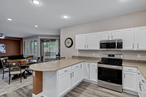 a kitchen with granite countertop a stove sink and microwave